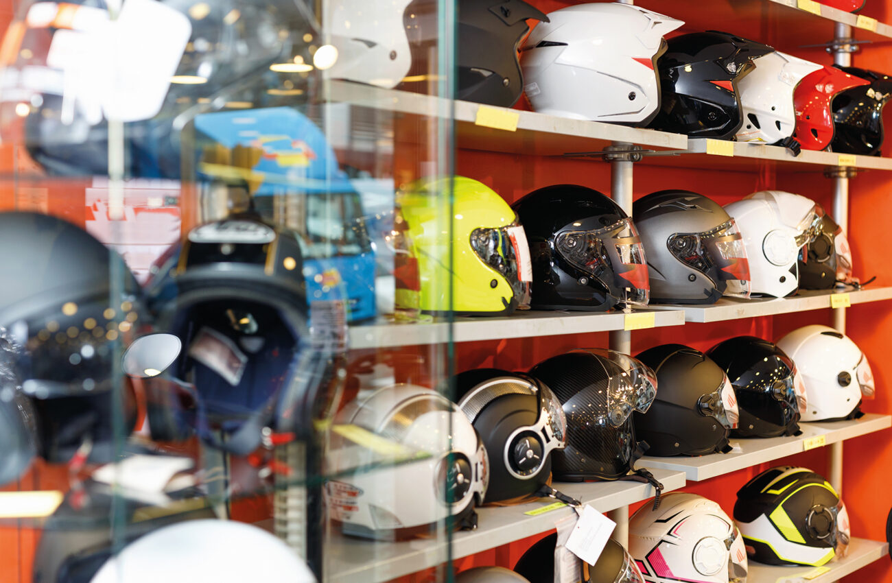 Interior of moto salon with colorful motorcycle helmets on shelv